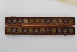 A vintage 20 th century die's set of button casts / presses complete in the original cases.