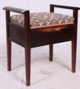 An Edwardian beech wood piano stool being raised on tapered supports with hinged upholstered seat