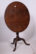 A 19th century country oak Georgian tilt top tripod occasional table.