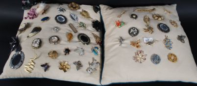 A large collection of costume jewellery brooches displayed on two pads