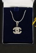 A Chanel style pendant necklace in the form of 2 crossed c's being complete with the  chain