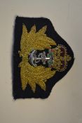 A good Royal Navy officers cap badge having leaves flanking anchor and crown,
