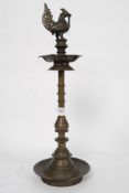 A large Indian bronze butter lamp together with a stone carved Buffalo on plinth