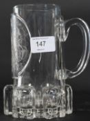 A 19th century German glass tankard of unusual form with chased detailed monogram to centre