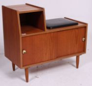 A retro 1960's Danish style telephone seat having a black vinyl seat with cupboards beneath.