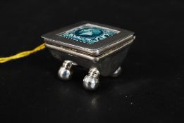 A silver stamp case raised on ball feet with hinged top and notation recess. Measures: 25g.