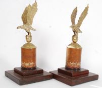 A pair of 20th century brass eagles mounted on leather and wooden mounts