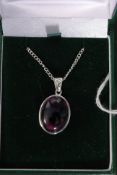 A silver and amethyst oval set pendant necklace and chain. Measures:7g.
