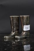 A pair of 20th century novelty silver plated boot shaped drinking measures with their ceramic