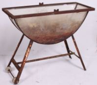 A vintage 20th century Industrial cast metal and resin set tyre bath stand having castors to the