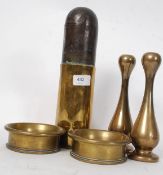 A pair of heavy brass candle sticks along with a pair of brass trench art ash trays also  a trench