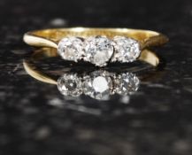 An 18ct gold and platinum vintage three stone diamond ring. 20pts. Measure: 1.8g size J.