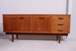 A vintage 1970's Danish style retro teak low sideboard dresser raised on tapered legs with wide