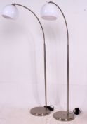 A pair of polished metal retro angular standard lamps having circular bases,