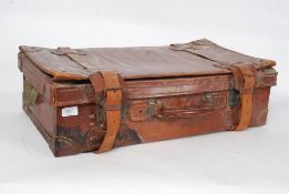 A vintage early 20th century good quality leather suitcase having lined interior with clasps and
