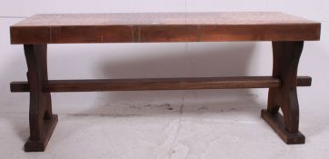 A vintage 20th century wooden and copper top rectangular coffee table raised on shaped supports.