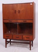 An excellent 1970's teak side cabinet raised on squared legs having a series of drawers and glass