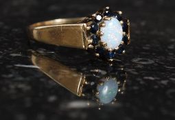 A 9ct gold opal and sapphire garnets ring. Measures: 3.7g size V.