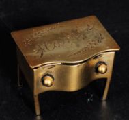 An early 20th century brass desk top stamp holder in the form of a chest having hinged top