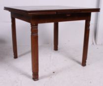 A 1930's oak draw leaf dining table being raised on squared legs with a draw leaf table top above