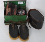 A vintage tin wall hanging kit with brushes and polish along with a pair of Ebony and silver