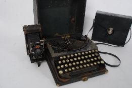 A  vintage portable typewriter in case together with a vintage camera and a pair of binoculars