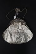 An Edwardian ladies silver hallmarked evening bag with fabulous rococo pierced support and handle