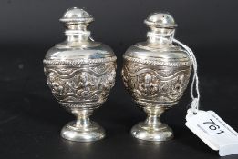A pair of siam silver thai table condiments- salt and pepper pots cast in relief with deitys raised
