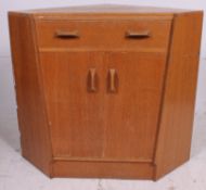A 1950's Ernest Gomme for G-Plan corner desk secretaire having fall front pull out desk drawer over