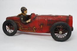 A vintage style large carved wooden model of a racing car with driver seated to inside.