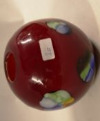 A 20th century studio glass vase in deep red, with colourful bursts to the sides.