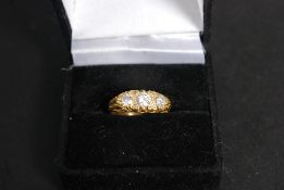 An 18ct gold 3 stone ladies diamond ring. The ring set with scolled head having inset 3 stones.