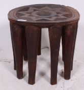 A 19th century? hand carved African Nupe tribal stool having circular top carved with detailed star