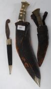 A large sheathed  Kukri knife along with another sheathed  smaller Kukri knife with a Solinger