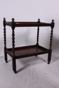 A 1930's oak barleytwist tea trolley having twin tiers with original castors having barley twist