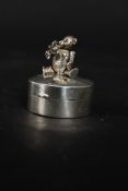 A 20th century circular silver pill box with articulated bear to the lid in seated position.