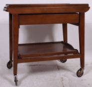 A 1970's teak wood Formica trolley raised on castors to the base having twin tiers with formica