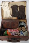 A vintage suitcase containing 1950's and earlier bags, silk scarves, gloves,