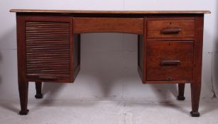 A 1920's Industrial Arts & Crafts revival oak tambour fronted twin pedestal desk.