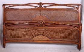 A good quality 20th century French walnut bergere caned kingsize bed frame.