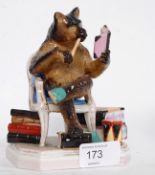A vintage Fischer & Mieg porcelain match holder in the form of a seated black forest bear reading