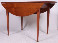 A retro 1970's large vintage teak drop leaf circular double drop leaf dining table raised on
