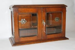 A Victorian Arts & Crafts style good quality oak smokers cabinet having bevelled glass panels with