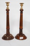 A decorative pair of wooden having reeded tapering columns with candlesticks complete with the
