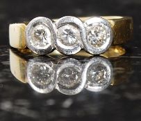 An 18ct gold three stone diamond ring. 5
