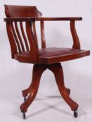 A 20th century Captains chair on swivel base raised on four legs fitted with later castors,