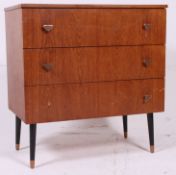 A retro 1970's teak wood chest of drawers having tapered ebonised legs with triangular handles.