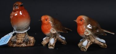 A Beswick model of a robin model no 980 together with a pair of Goebel Robins.