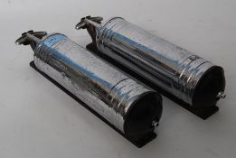 A vintage pair of chrome fire extinguishers by Pyrene complete with the wall brackets mounts