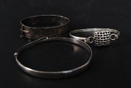 A collection of 3 ladies silver bangles to include a 925 rococo chase banded bracelet,